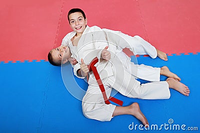 Two young athlete with a red and white belt show finger super