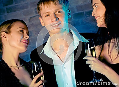 Two young attractive sweet women and man with champagne glasses