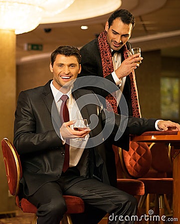 Two young men behind gambling table