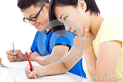 Two young students exams together in classroom