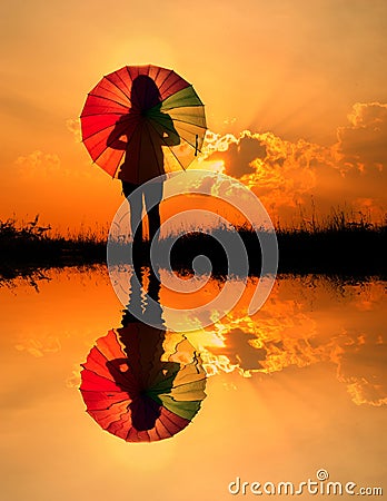 Umbrella woman and sunset silhouette,Water reflect