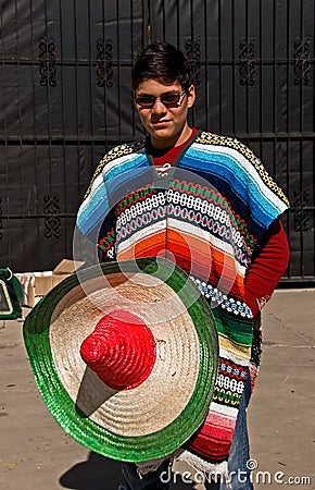 un-hombre-joven-en-poncho-colorido-y-un-sombrero-8366755.jpg