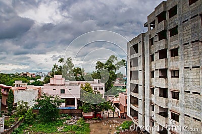 Under construction building with clouds and trees