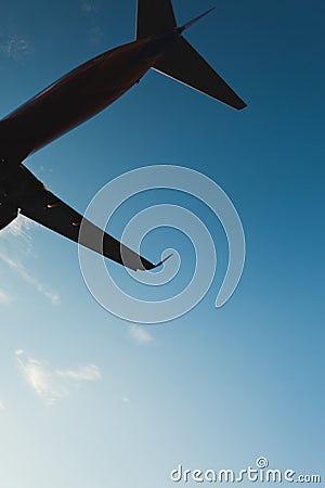 Underneath Airplane with pretty blue sky and clouds in backgroundUnderneath Airplane with pretty blue sky in background