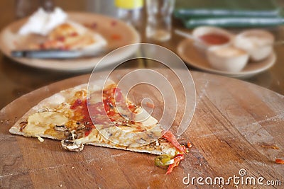 Uneaten piece of pizza in restaurant