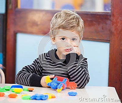 Unhappy Boy With Blocks In Classroom