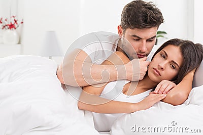 Unhappy young couple in bedroom