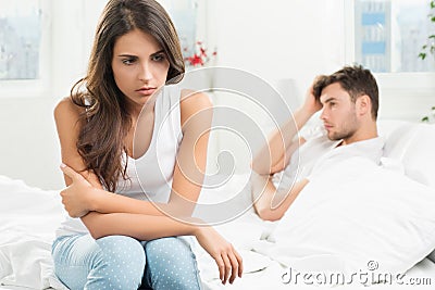 Unhappy young couple in bedroom