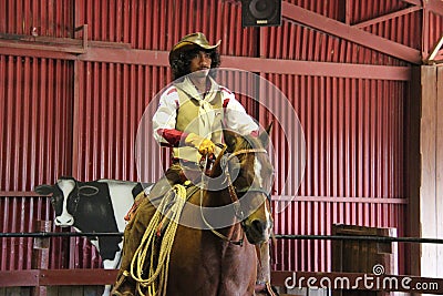 The unidentified cowboy is showing tourists how to ride a horse.