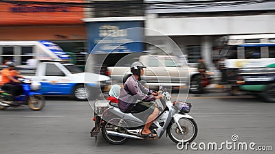 Unidentified family riding motorcycle in town
