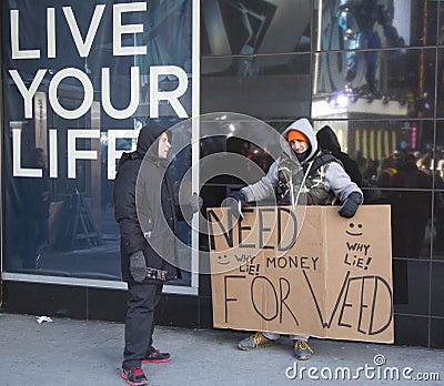 Unidentified man with sign asking for money to buy weed on Broadway during Super Bowl XLVIII week in Manhattan