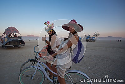 Unidentified man and woman riding a bicycle