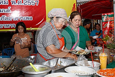 An unidentified Thai people sells pad thai on night market wall street.