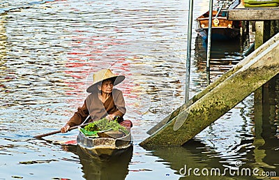 An unidentified Thai woman sells her goods in her boat