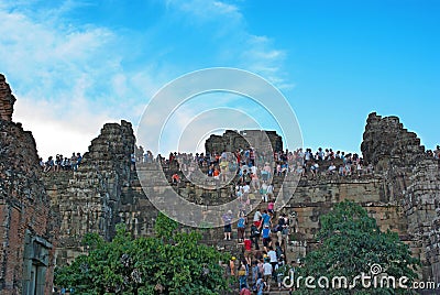 Unidentified tourists climbing a tower at Angkor Wat