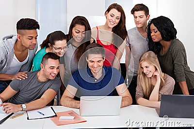 University students using laptop together