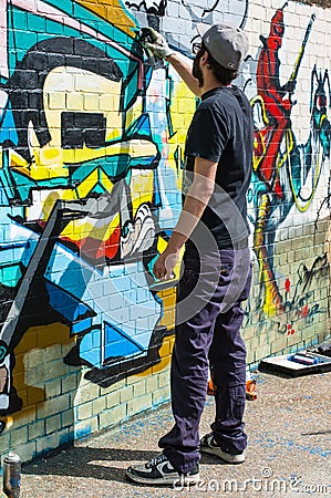 Urban artist drawing graffiti on a wall in Shoreditch.