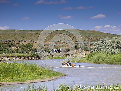 US Cavalry soldier holds on to horses tail in river