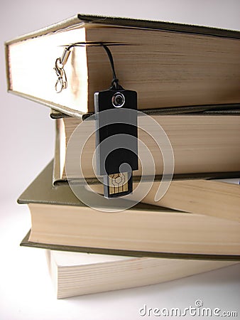 USB flash drive hanging in front of books.