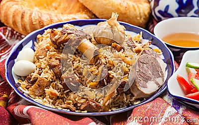 Uzbek national food pilaf on traditional fabric adras