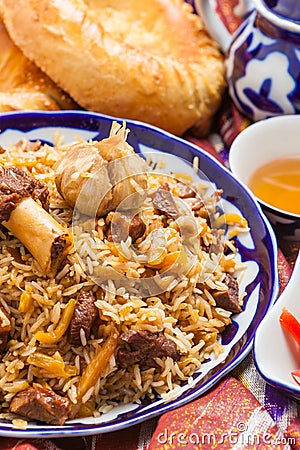 Uzbek national food pilaf on traditional fabric adras