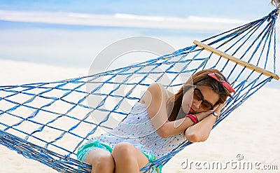 Vacation woman relaxing on beach in hammock on summer