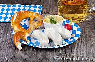 Veal sausage and pretzel on a paper plate