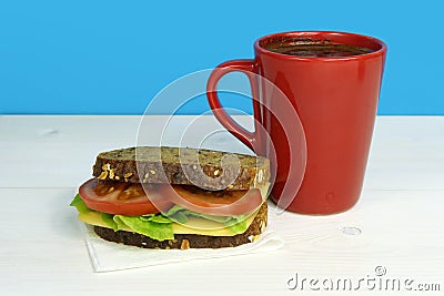 Vegetarian sandwich and cup of coffee on white wooden table