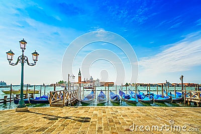 Venice, street lamp and gondolas or gondole and church on background. Italy