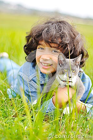 Very cute little girl with cat on meadow