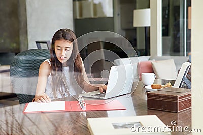 View Of Teenage Girl Using Laptop Through Window