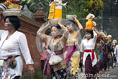 Village women carry offerings of food baskets