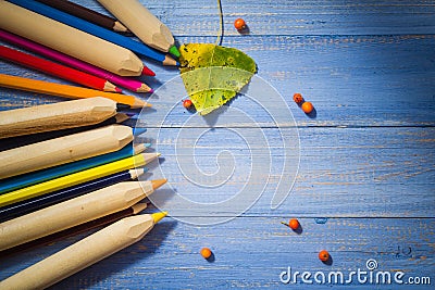 Vintage background colored pencils autumn fruits blue table