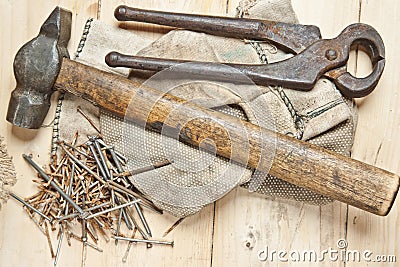 Vintage hammer with nails on wood background