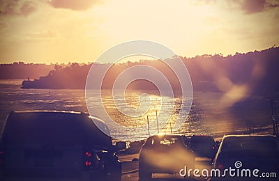 Vintage picture of road with cars in motion, blured against sun.