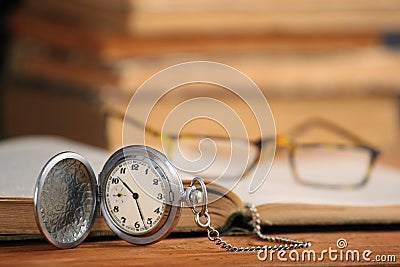 Vintage pocket watch glasses and open old book