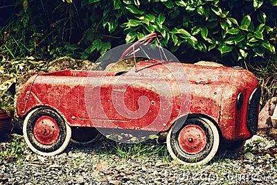 Vintage Red Toy Car in a Garden