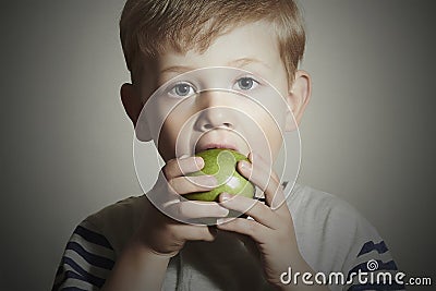 Vitamin.Child eating apple.Little Boy with green apple. Health food. Fruits