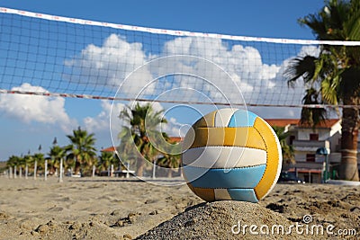 Volleyball net, volleyball on beach and palm trees