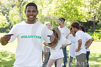 Volunteer pointing at tshirt in park