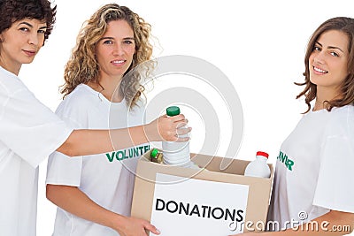 Volunteer women putting food in donation box