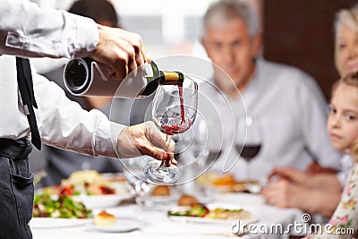 Waiter pouring wine in glass