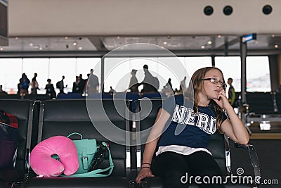 Waiting at the airport, or girl sitting alone in generic locatio