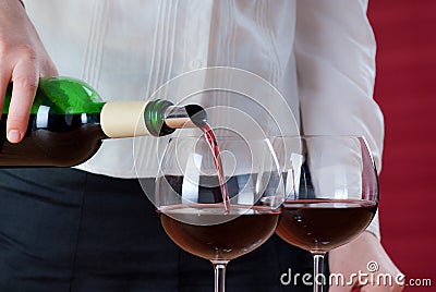 Waitress pouring red wine