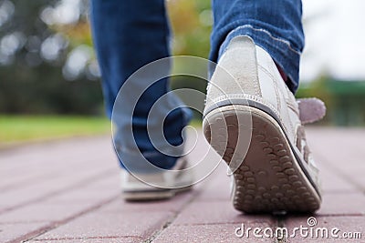 Walking in sport shoes on pavement