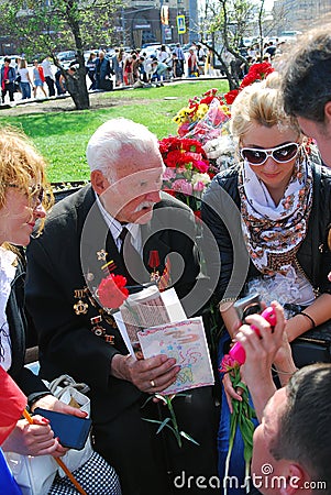 A war veteran holds flowers.