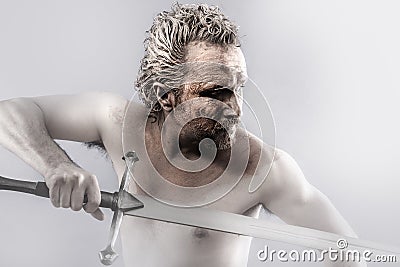 Warrior man covered in mud with sword