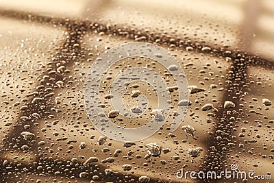 Water drops in a shiny metallic surface with table re