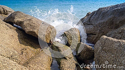 The waves break on the rocks