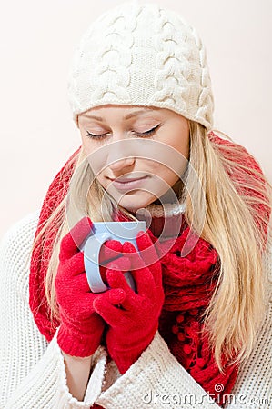 Wearing red knitted scarf and gloves with cup of drink